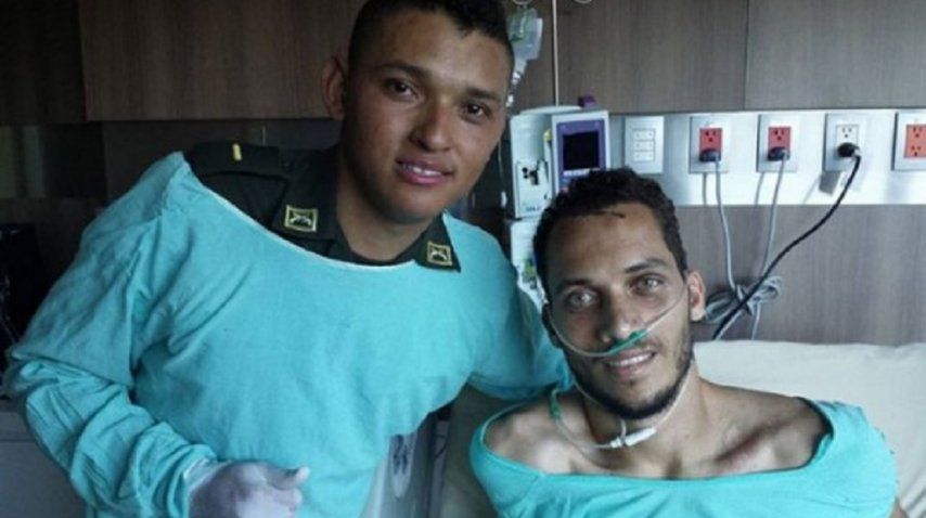 El defensor posa con el policía que le salvó la vida