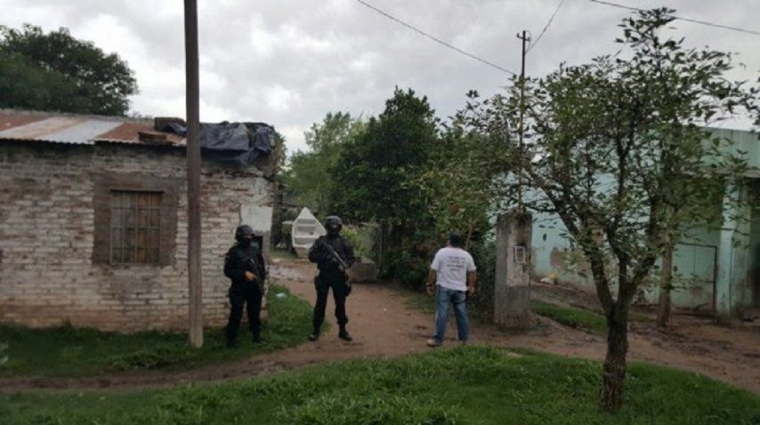 Policías llevando a cabo el allanamiento