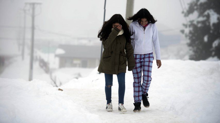 Dos chicas caminan en medio de la nieve en San Carlos de Bariloche